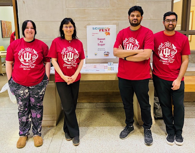 Four members of the Pohl lab wearing red Science Fest shirts on 1 November 2025
